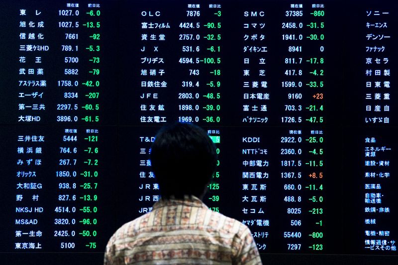 Женщина изучает котировки на табло Токийской фондовой биржи 29 июня 2015 года. Азиатские фондовые рынки снизились в понедельник в страхе перед дефолтом Греции. REUTERS/Thomas Peter